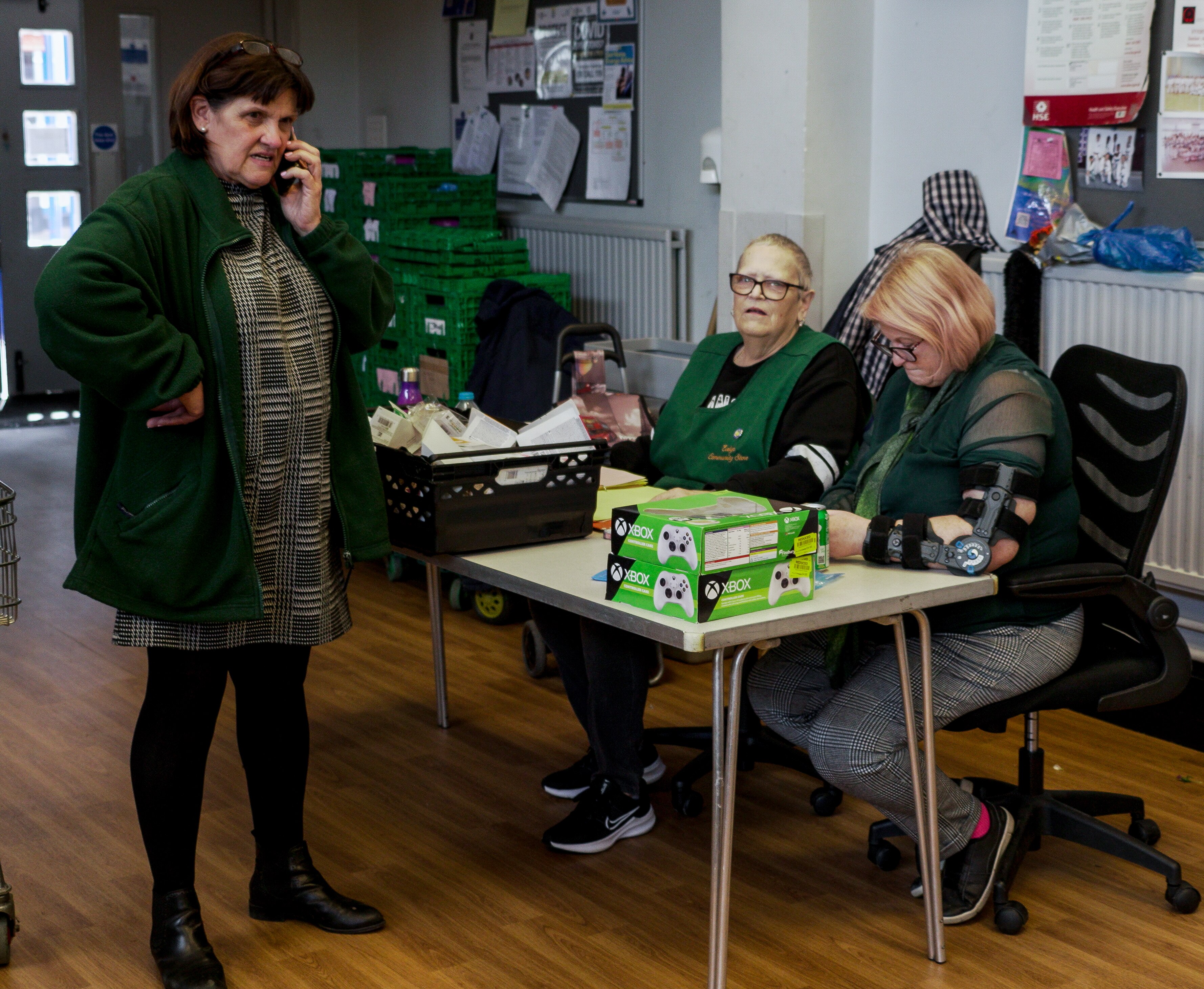 Christina speaks on the phone while two others look at paperwork