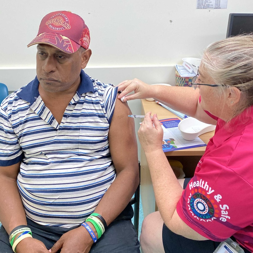 Man gets a vaccine from a female nurse.