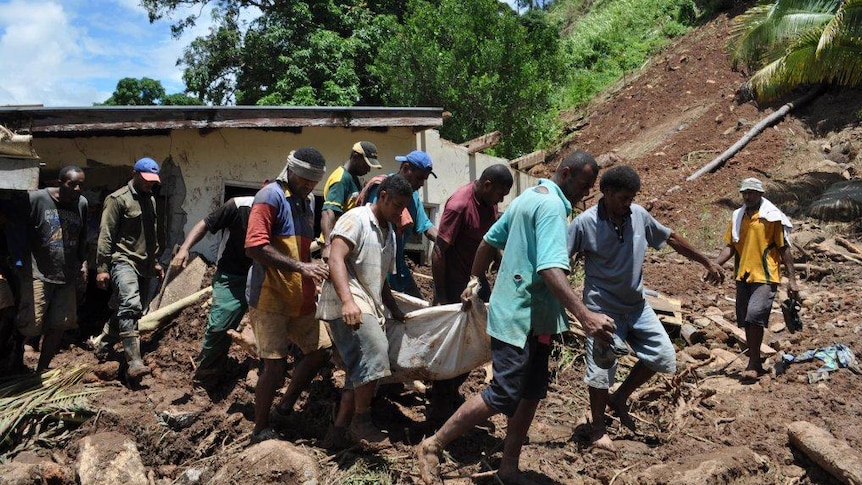 Tukuraki villagers recover one of the victims of the landslide.
