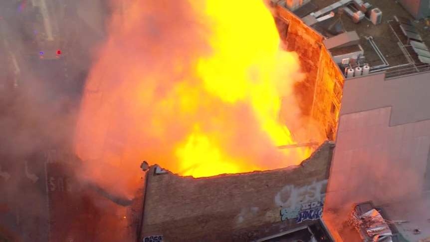 Aerial vision shows building collapse as it's engulfed in flames