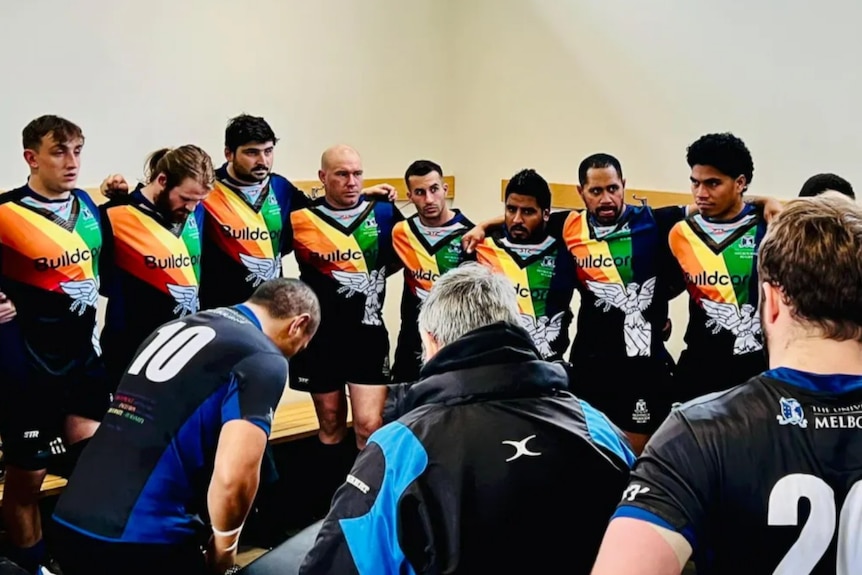 Athletes wearing rainbow shirts during a team talk