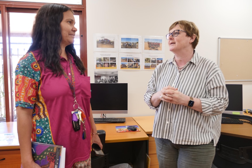 two women chat to each other in an office