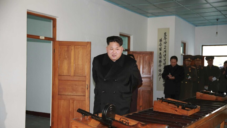 Kim Jong-un looks at guns.