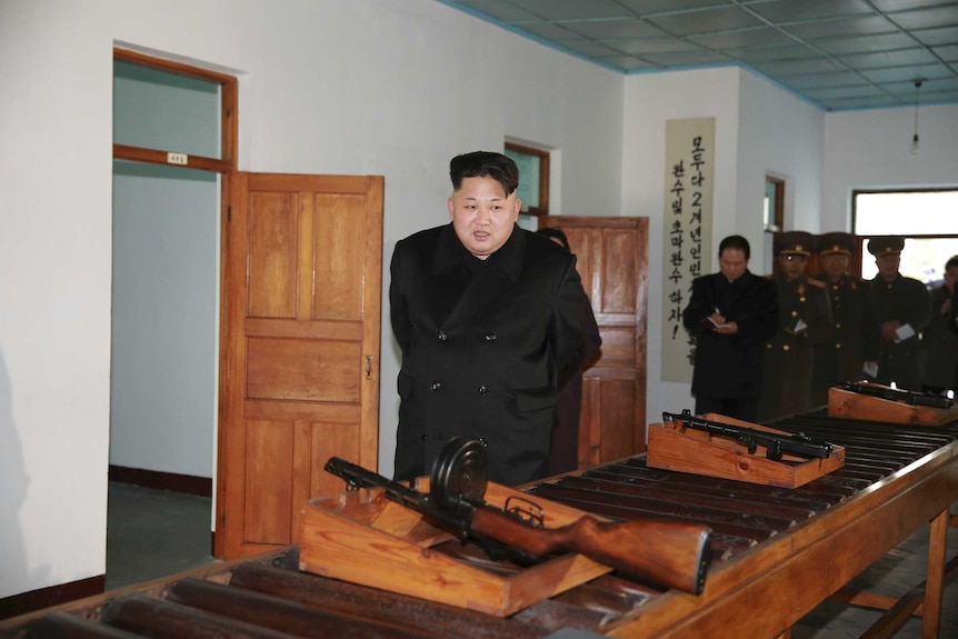 Kim Jong-un looks at guns.