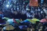 Protesters use umbrellas to block the pepper spray from office officers outside the Chinese central government's liaison office in Hong Kong, Sunday, Nov. 6, 2016.