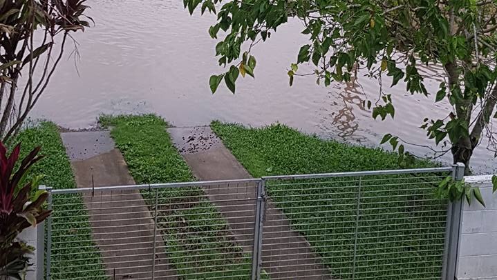 Floodwaters approaching front fence of house at Halifax, near Ingham in north Queensland.