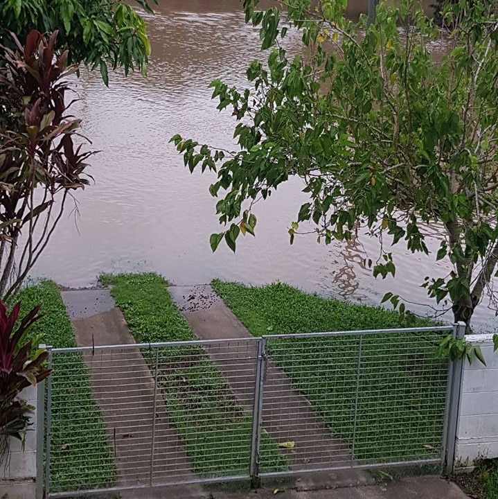 Floodwaters approaching front fence of house at Halifax, near Ingham in north Queensland.