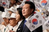 A man in suit waving South Korean national flag. 