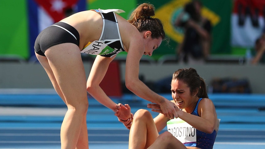 Nikki Hamblin of New Zealand stops running during the race to help fellow competitor Abbey D'Agostino of USA
