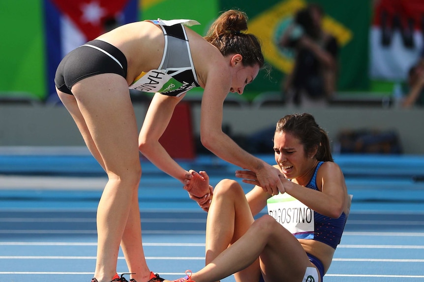 Nikki Hamblin of New Zealand stops running during the race to help fellow competitor Abbey D'Agostino of USA