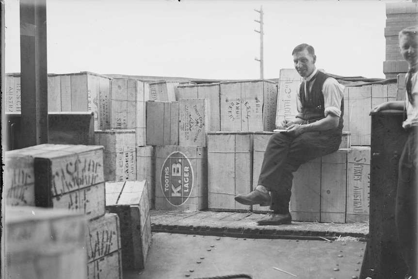 Bar staff sit on crates of alcohol from the first post prohibition delivery to Canberra.