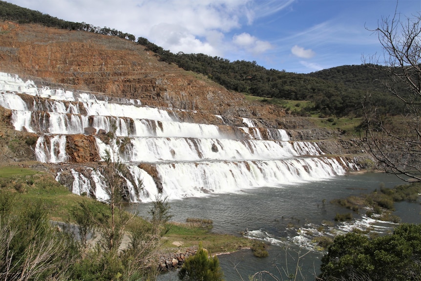 Water flows over a dam spillway
