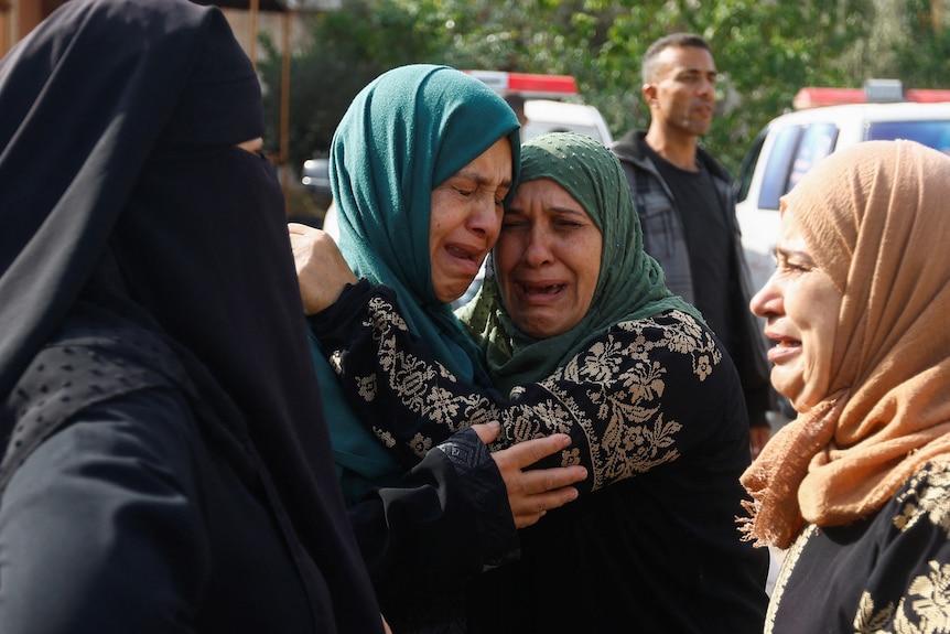 Two women embrace crying at a funeral in Gaza. 