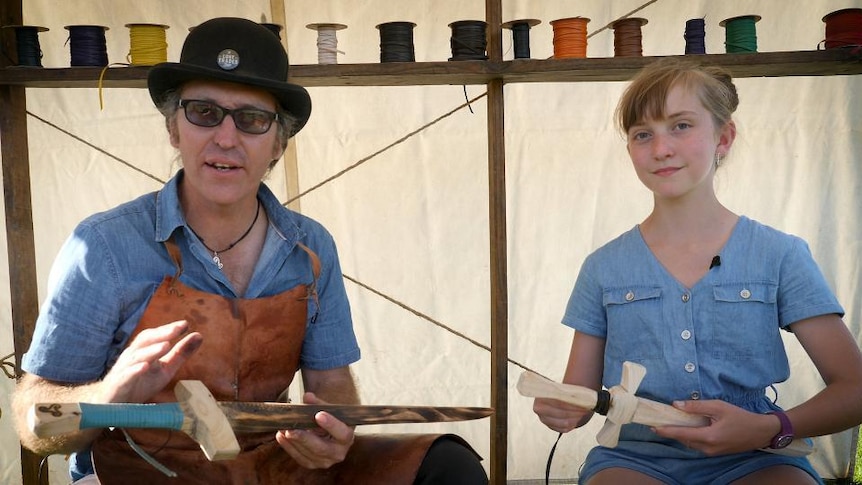 Man and girl hold toy wooden swords