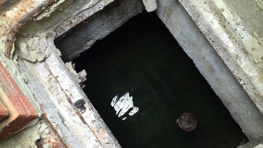 A rectangular-shaped hole in the basement of Australia House reveals a well of water.