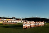 Carlton and Collingwood players line up for the national anthem at the opening AFLW game in 2018