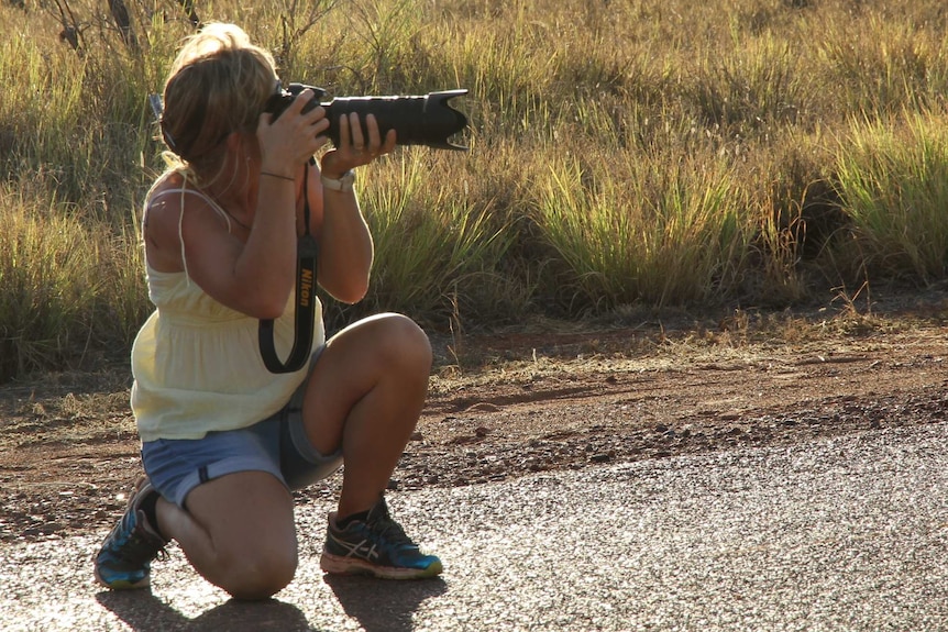 a young woman taking a photograph