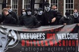 Masked National Action members hold a banner with an image of Hitler. It reads: 'Refugees not welcome Hitler was right'.