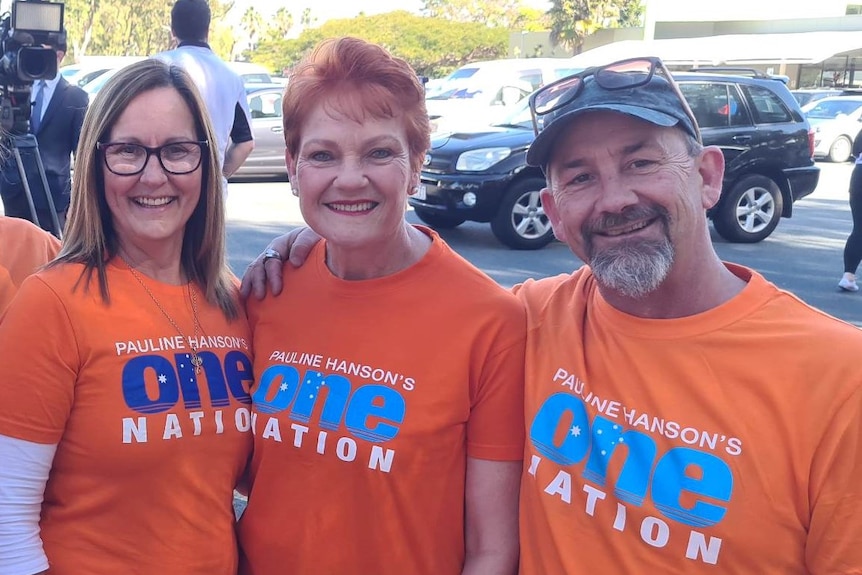 sandy roach pauline hanson and a man in one nation shirts posing and smiling