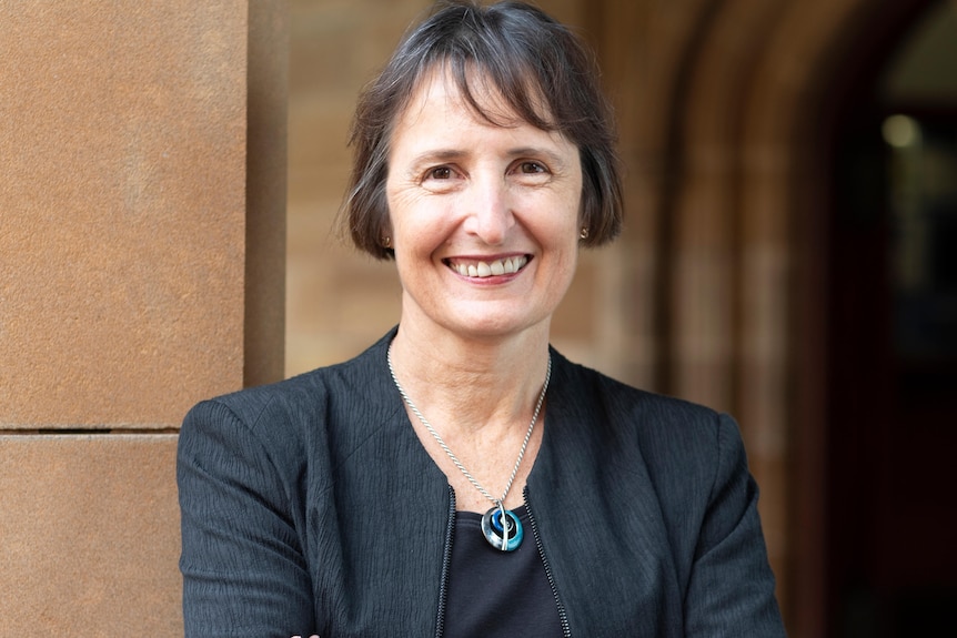 a woman with her arms crossed smiling