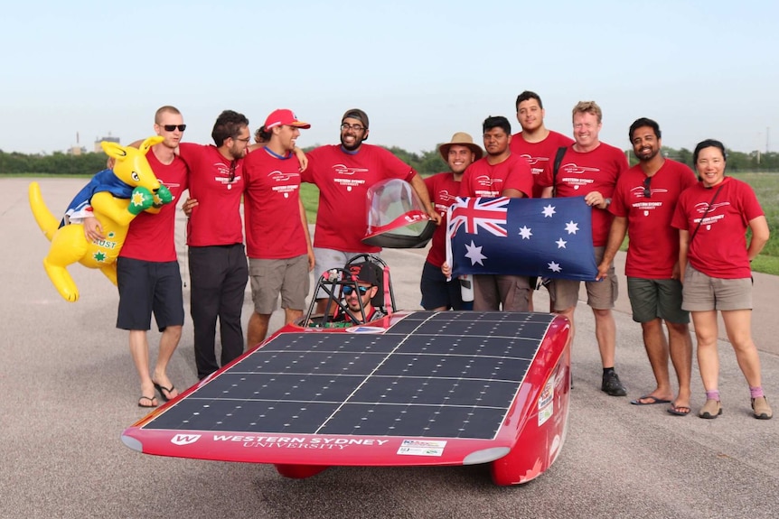 People in front of a solar car