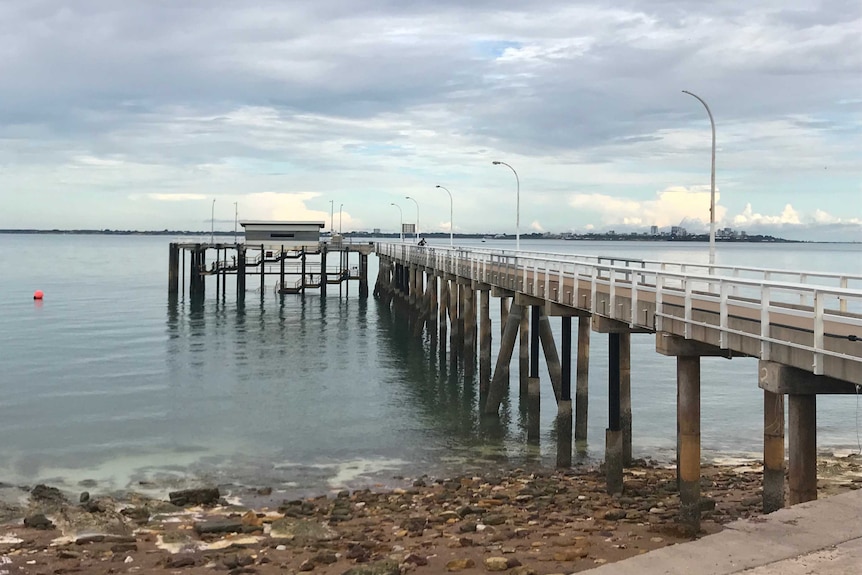 Mandorah jetty under grey clouds.