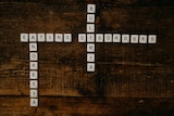 Letter tiles spelling out eating disorders on a wooden board