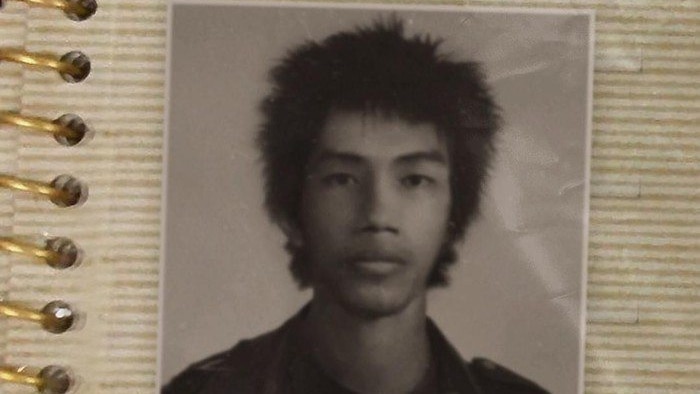 An old photo of a young Asian man with spiky hair