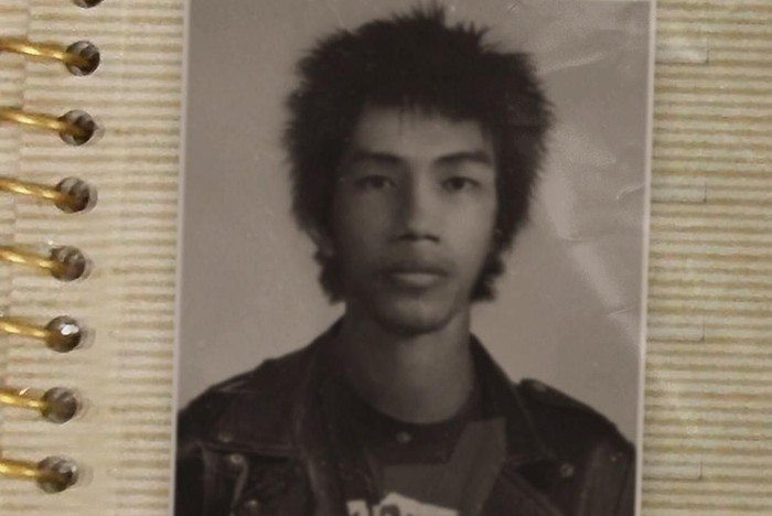 An old photo of a young Asian man with spiky hair