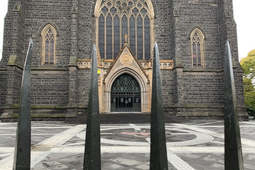 A view of the steps outside St Patrick's Cathedral, framed by the iron gates.