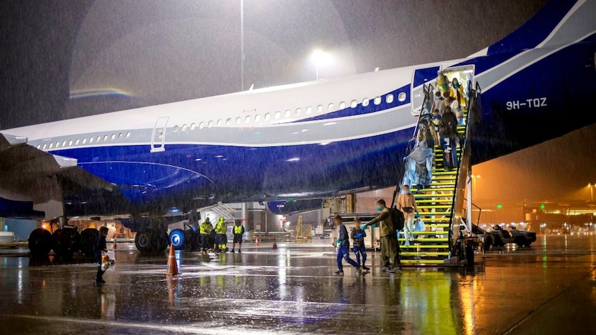 A planeload of passengers disembarking an aircraft