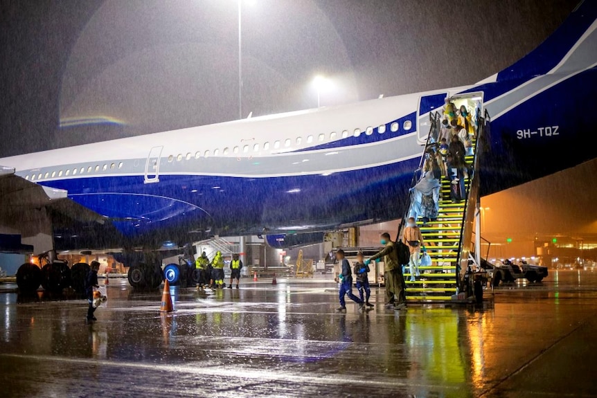 A planeload of passengers disembarking an aircraft