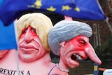 Protesters hold up caricatures of Boris Johnson and Theresa May at an anti-Brexit rally