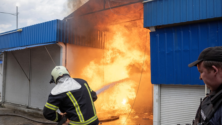 fire fighters putting out flames in a Ukrainian market struck by Russian forces