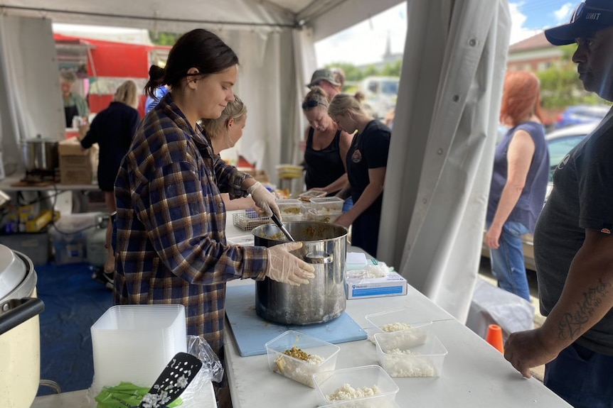 A woman serves food to people