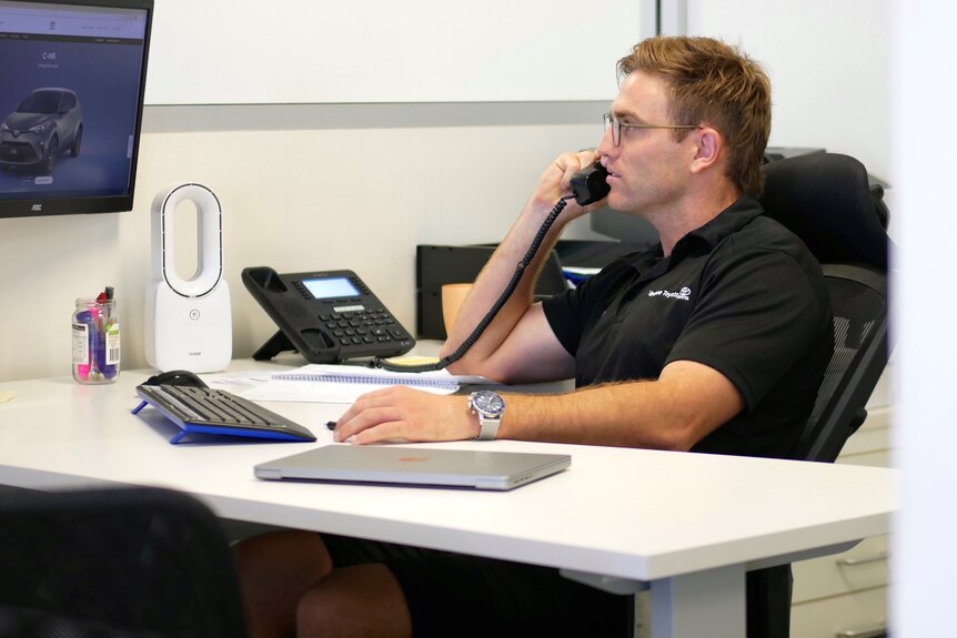 Brad Sheppard works at his office desk in Broome Toyota. 