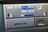 A digital display of a car showing the outside temperature in 51 degrees Celsius