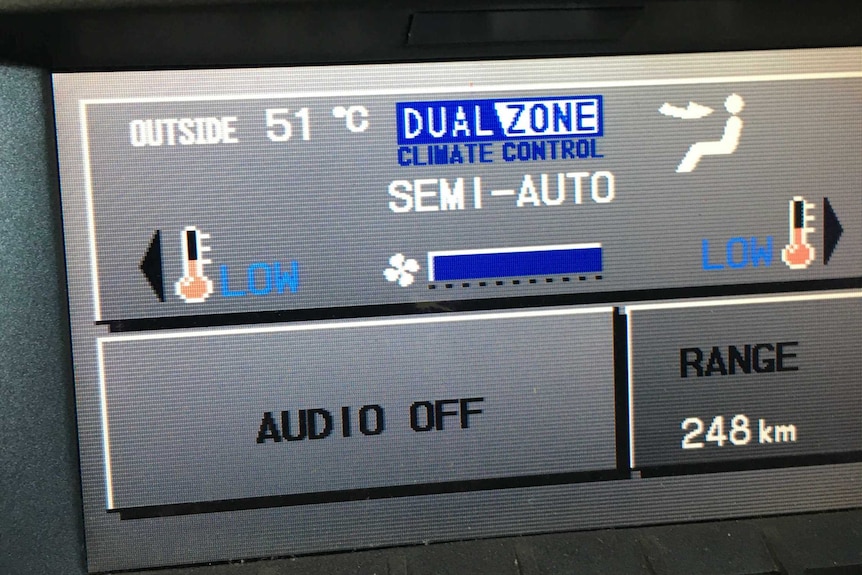 A digital display of a car showing the outside temperature in 51 degrees Celsius