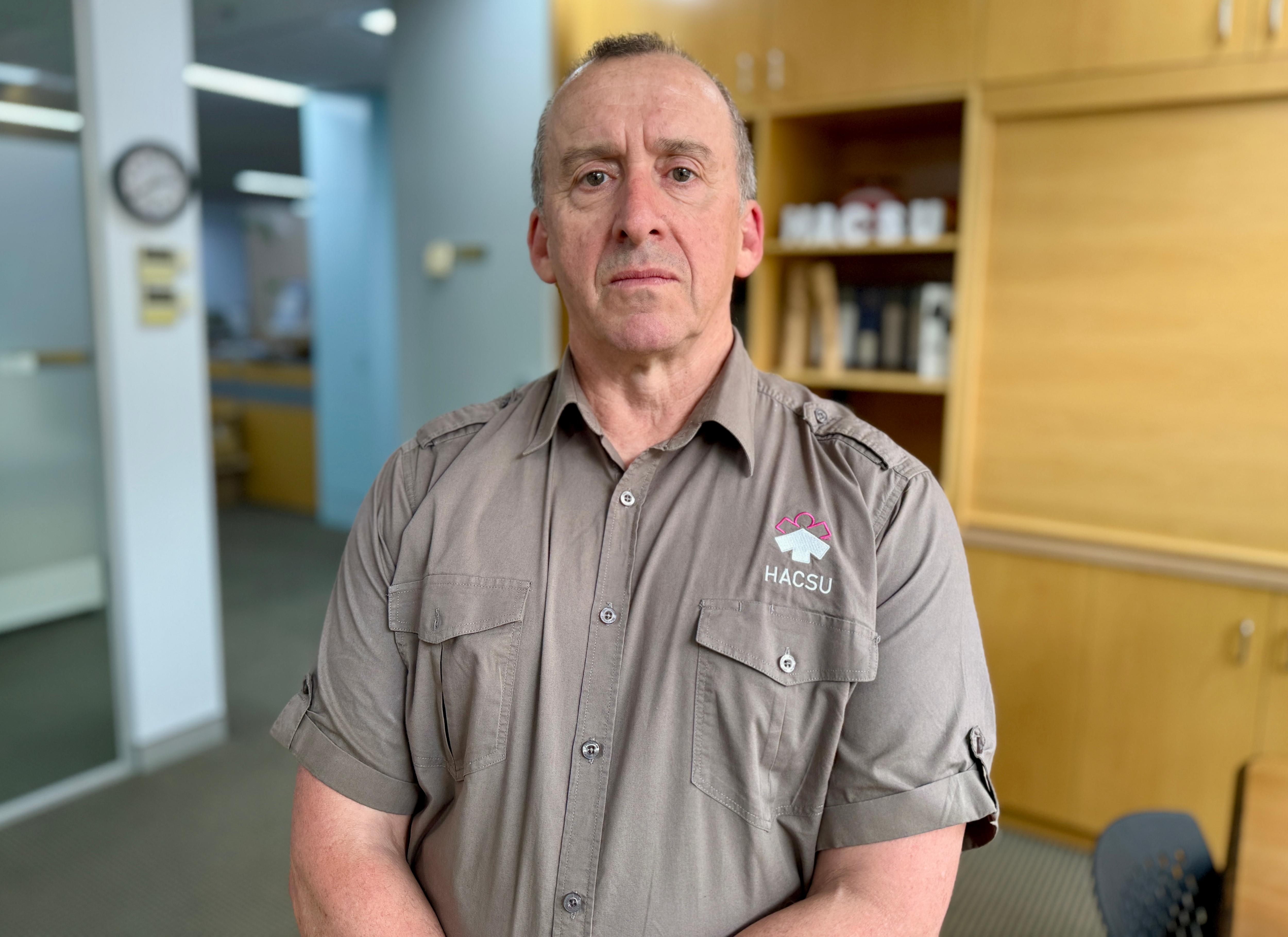 Retrato de un hombre que llevaba una camisa con botones de color caqui.