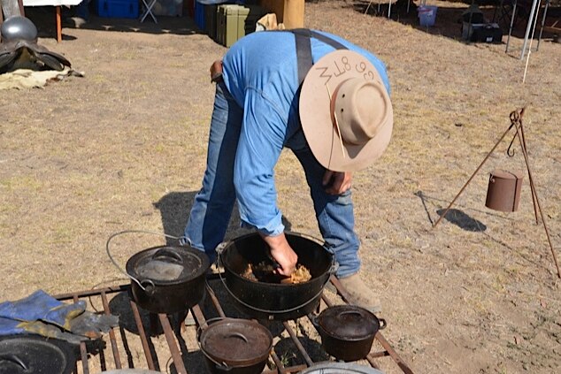 Man stokes coals during Camp Oven Championships
