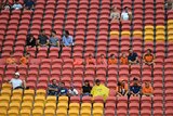 Football fans sit in a sparsely occupied section at Lang Park during the Roar versus the Jets.