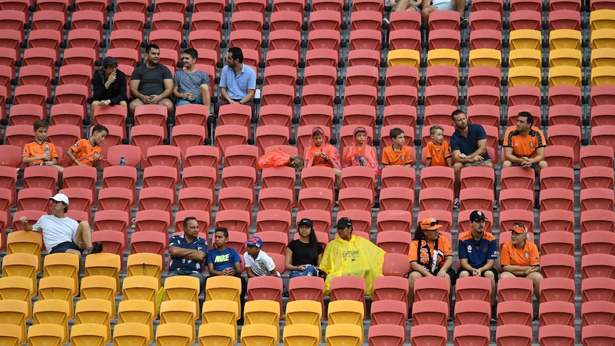 A small number of fans sit scattered amongst empty seats.