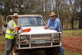 BlazeAid volunteer Dennis Bishop and farmer Jon Chaseling lean over a ute.