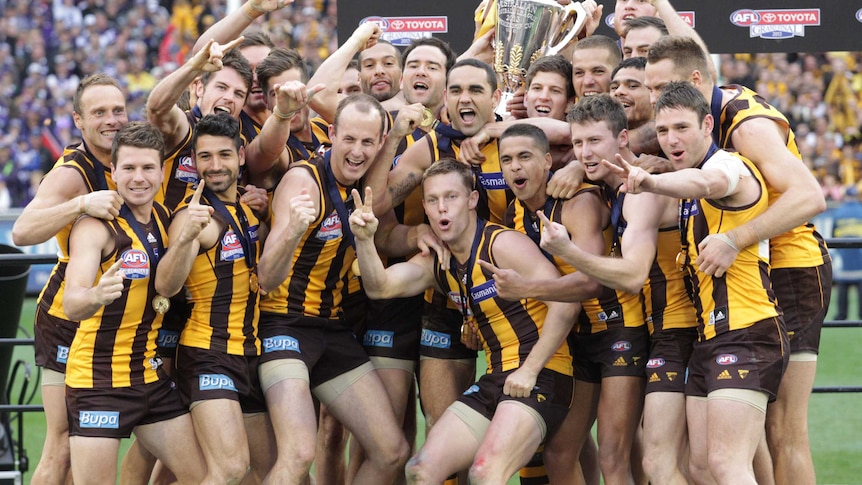 Hawthorn players celebrate with the AFL premiership cup after beating Fremantle in the grand final.