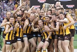 Hawthorn players celebrate with the AFL premiership cup after beating Fremantle in the grand final.