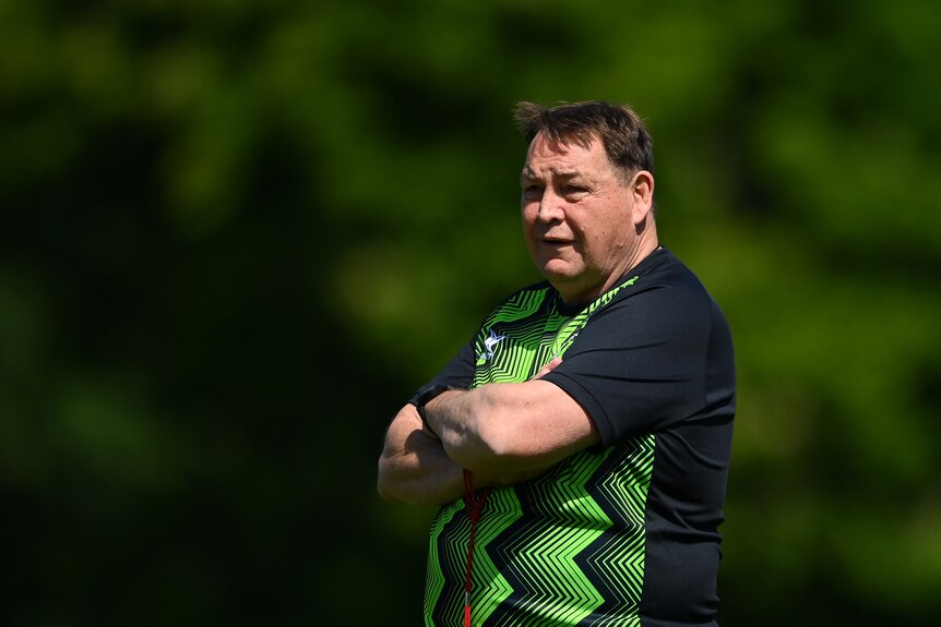 Steve Hansen stands with his arms folded