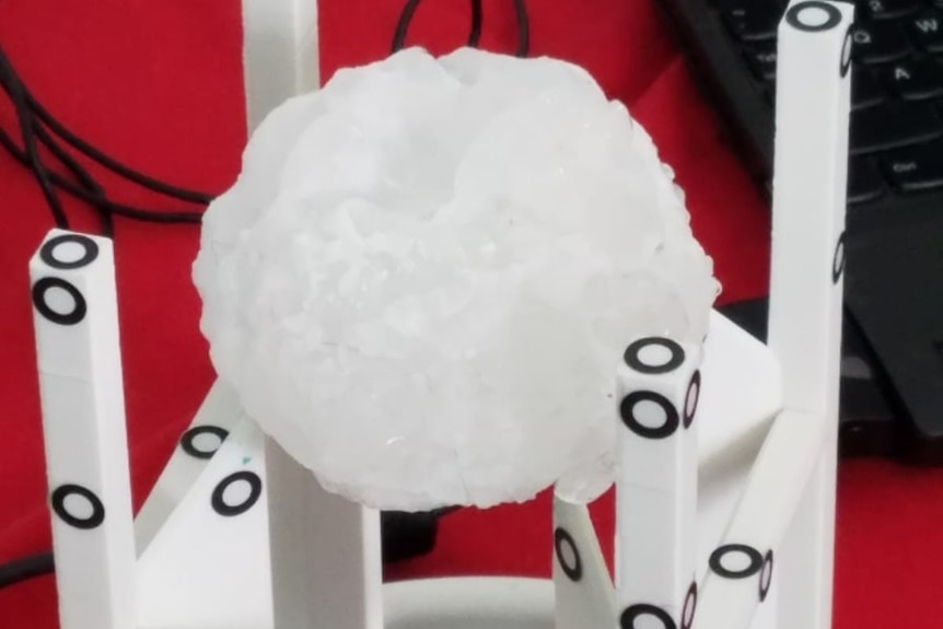 A large hail stone is examined and scanned.