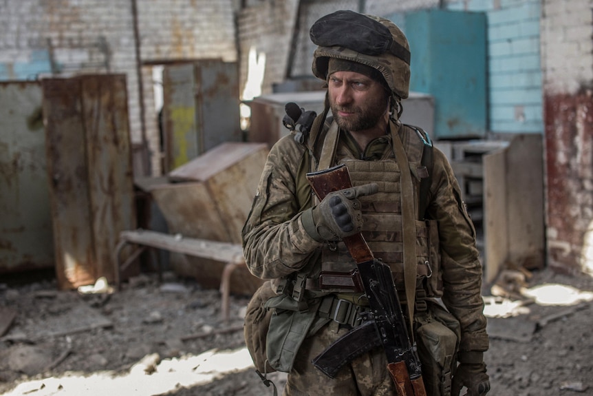 A Ukrainian service member looks on in the industrial area of the city of Sievierodonetsk