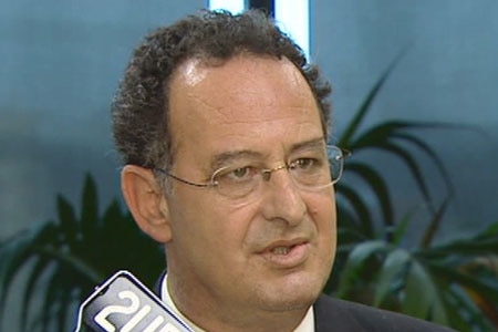 A younger-looking Milton Orkopoulos in the early 2000s, with glasses and curly hair