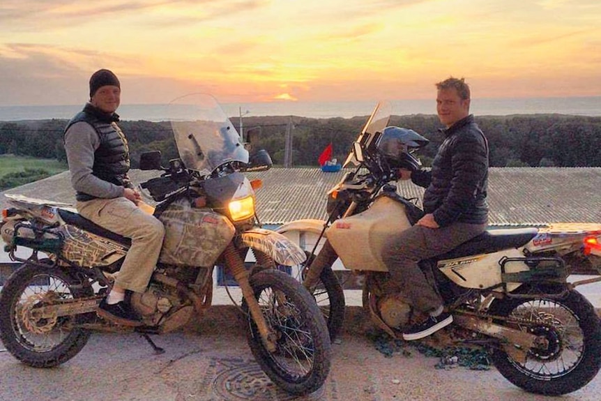Brothers Dylan and Lawson Reid, sit on their motorbikes in front of a sunset in Morocco in 2016.